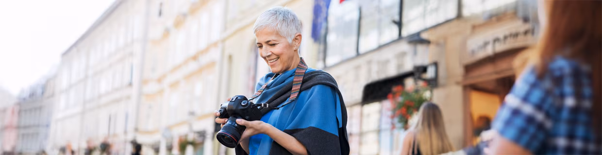 Ältere Frau mit Fotoapparat in der Hand