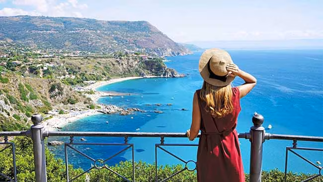 Italien - Kalabrien, Frau auf Aussichtspunkt mit Blick auf die malerische Bucht von Capo Vaticano
