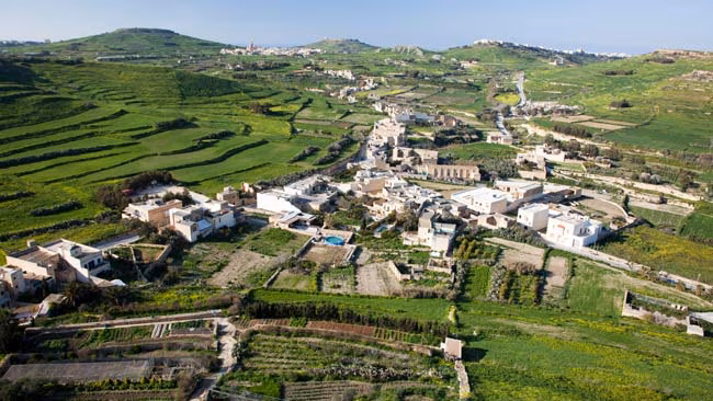 Malta - Insel Gozo, Grüne Felder mit kleinem Dorf mit traditioneller Architektur