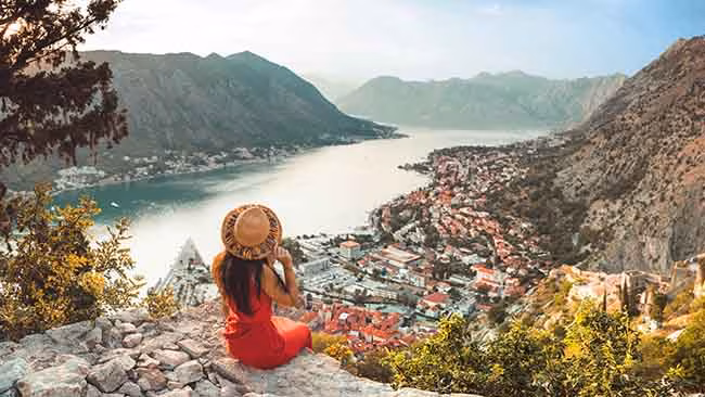 Montenegro, Frau auf Felsen mit traumhaftem Blick auf die Bucht von Kotor