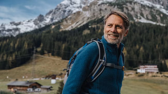 Bergsteiger mit Wanderrucksack beim Wandern vor dem Hochkönig Berg, Salzburger Land, Österreich