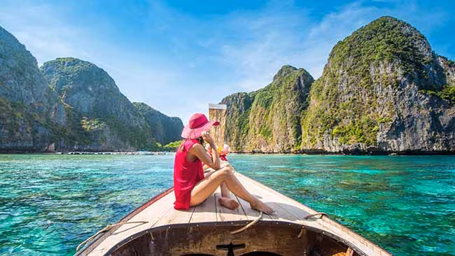 Asien - Thailand, Frau auf Boot im Meer mit Felsen