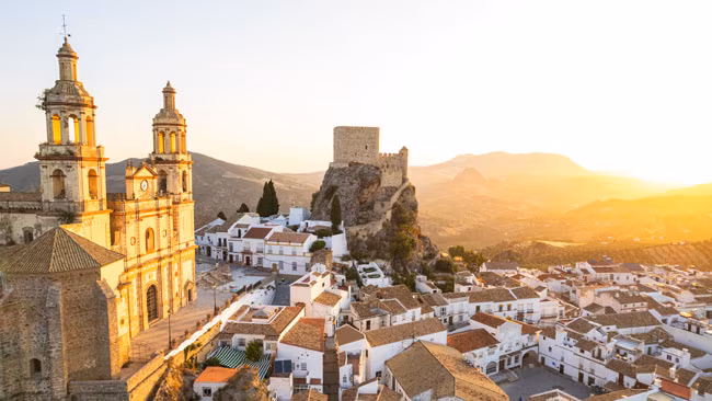 Spanien - Andalusien, Dorf Olvera in Cádiz mit Ansicht auf Kirche Nuestra Señora de der Encarnación auf Hügel im Sonnenuntergang