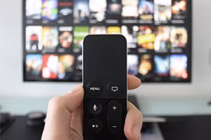 Hand mit Fernbedienungor dem Fernseher