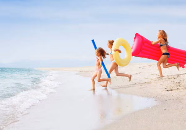 Urlaub polnische Ostsee mit Kindern Kinder mit Luftmatratze am Strand