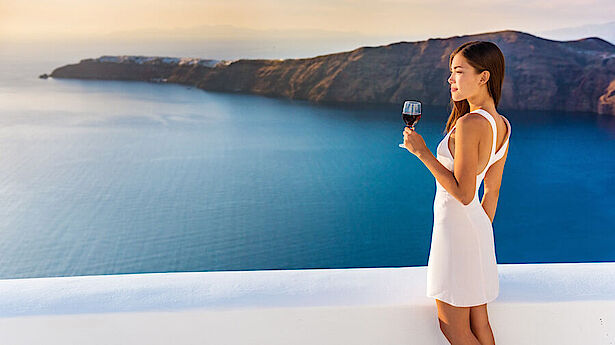 Frau mit Wein vor griechischem Meer