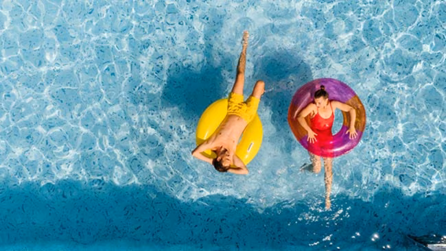 Paar entspannt in Schwimmreifen im Pool im Sommerurlaub