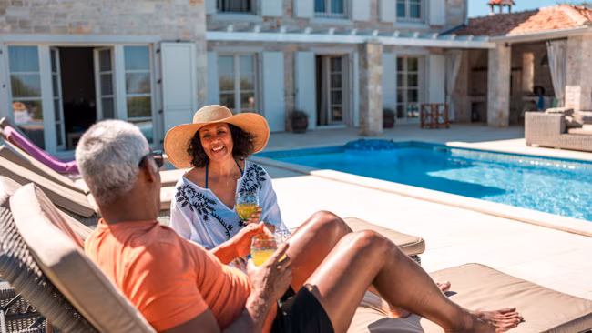 Älteres Paar entspannt in Liegen am Pool in Villa, Finca, Ferienhaus