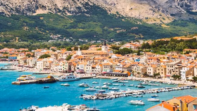 Kroatien - Istrien, Blick auf Stadt Baska mit Hafen und Bergen im Hintergrund auf der Insel Krk