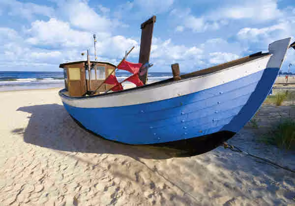 Blaues Fischerboot am Nordsee-Strand