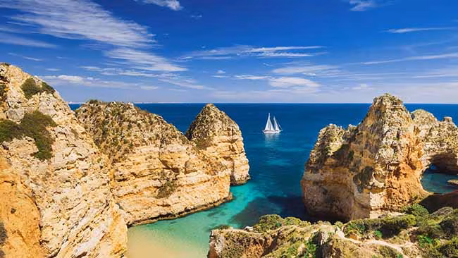 Portugal Algarve, Bucht mit Felsen und Schiff auf dem Meer