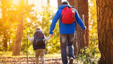 Vater und Kind spazieren im Wald
