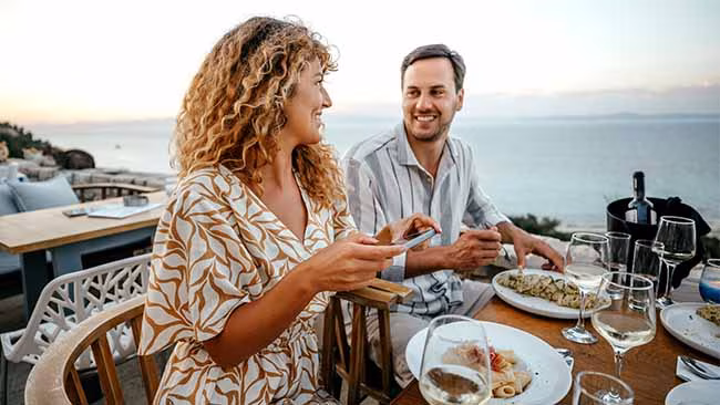 Paar, Gemeinsames Essen mit Meer im Hintergrund