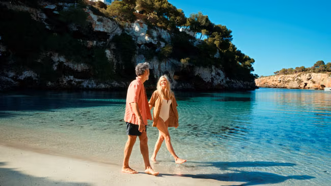 Paar am Strand spazierend bei Landausflug auf Mallorca, TUI Cruises