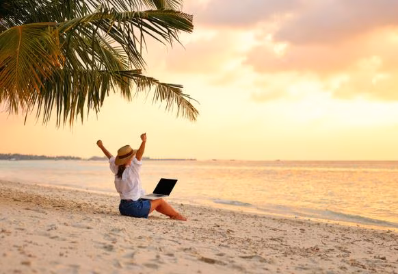 Frau mit Notebook am Strand