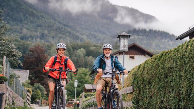 Senioren Paar beim Radfahren in Bergkulisse, Aktivurlaub, Österreich