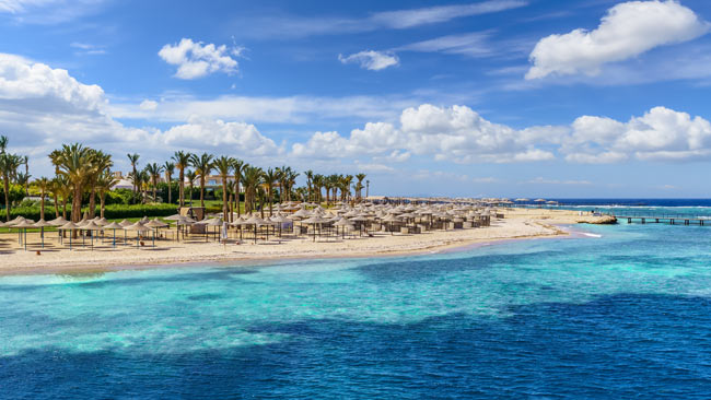 Landschaft mit Strand und Liegen in Port Ghalib, Marsa Alam, Ägypten
