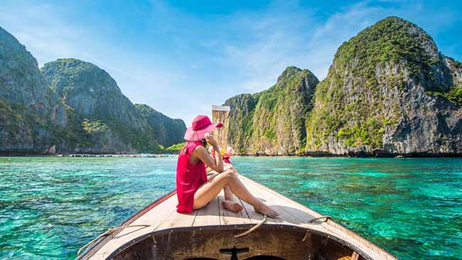 Asien - Thailand, Frau auf Boot im Meer mit Felsen