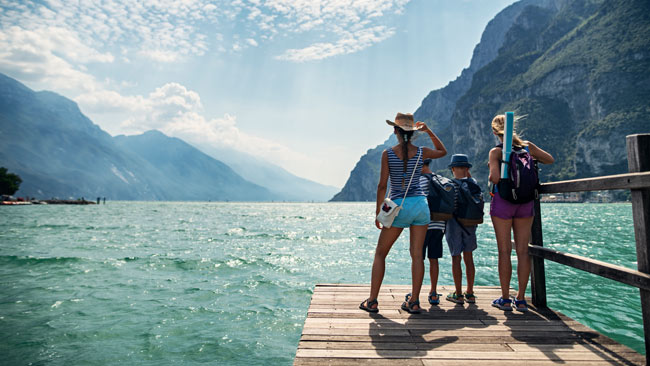 Italien - Gardasee, Familie steht auf Pier und blickt auf Gardasee