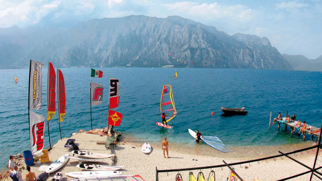 Gardasee - Strandabschnitt im Norden, Treffpunkt für Windsurfer, Berghänge und Gardaseeberge im Hintergrund