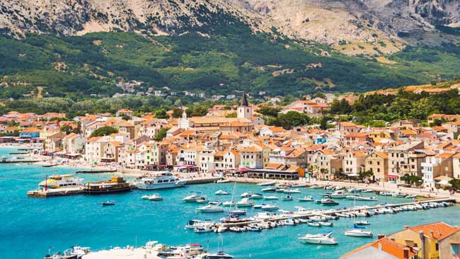 Kroatien - Istrien, Blick auf Stadt Baska mit Hafen und Bergen im Hintergrund auf der Insel Krk