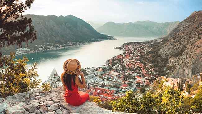 Montenegro, Frau auf Felsen mit traumhaftem Blick auf die Bucht von Kotor