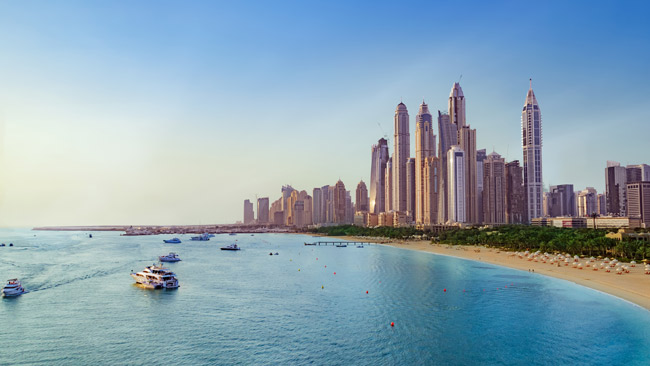 Aussicht auf Dubai Skyline vom Meer aus, Boote am Strand, Vereinigte Arabische Emirate