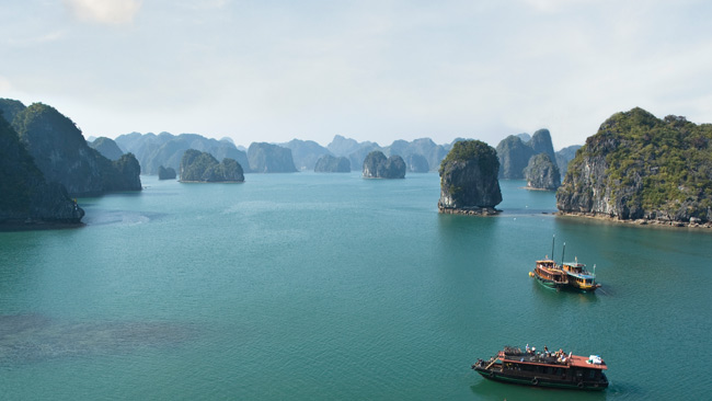 Halong-Bucht mit Booten und großen Felsen im Wasser, Vietnam