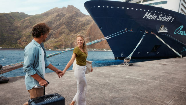 Mein Schiff 1 Kreuzfahrtschiff, Paar am Pier im Hafen mit Gepäck