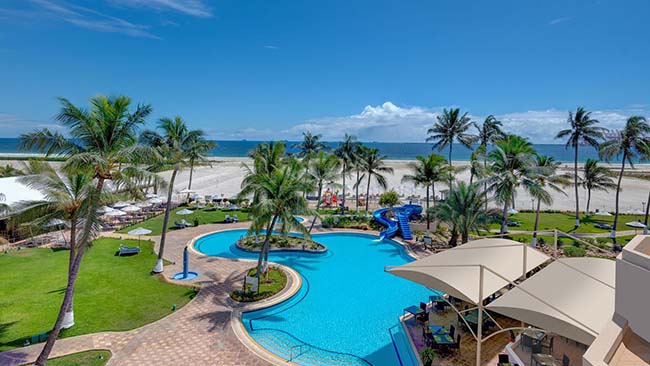 Oman - Salalah, Hilton Salalah Resort, Poolanlage mit Meer und Palmen im Hintergrund