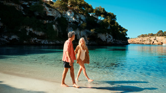 Paar am Strand spazierend bei Landausflug auf Mallorca, TUI Cruises