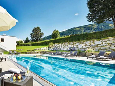 Alpenhaus Kaprun - Pool mit Liegen und Obsttellertisch 
