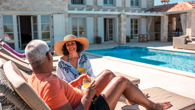 Älteres Paar entspannt in Liegen am Pool in Villa, Finca, Ferienhaus