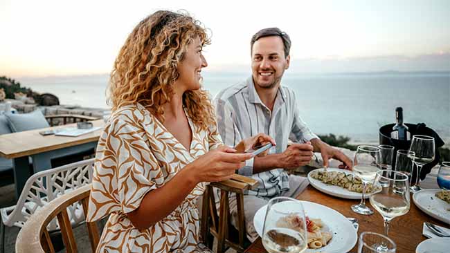 Paar, Gemeinsames Essen mit Meer im Hintergrund