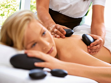 Dame Wird mit Steinen Massiert